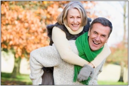 Senior man giving woman piggyback ride